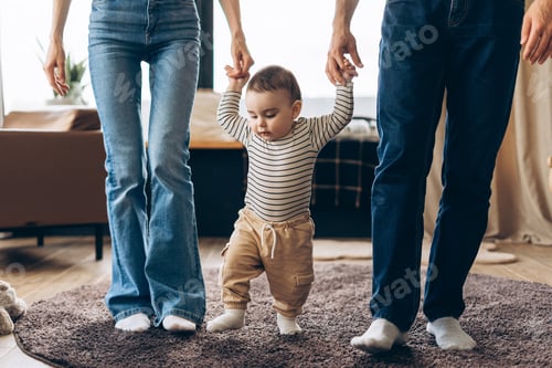 Preview: Happy family teaching baby to walk at home