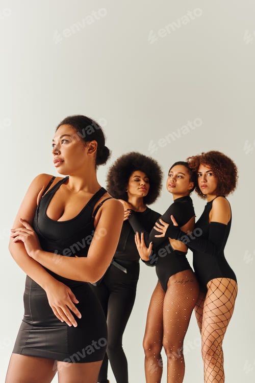 Preview: appealing sexy african american women in black stylish bodysuits posing together, fashion concept
