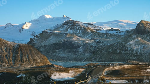 Preview: an empty road leads down to a snowy landscape and large mountains