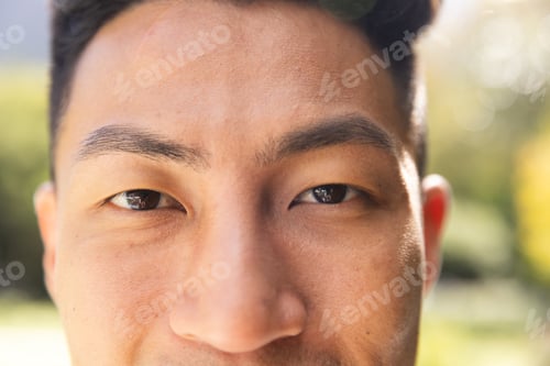 Preview: Portrait close up of happy asian man smiling in sunny garden