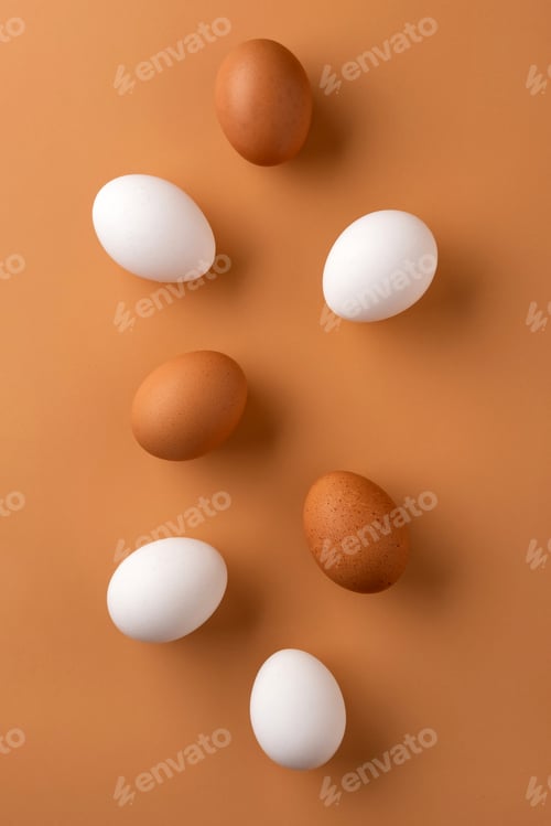 Preview: Brown and white chicken egges on beige background. Chicken eggs on the table.