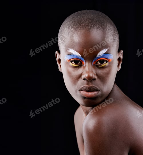 Preview: Studio portrait of a beautiful model posing with colorful eye makeup on a black background