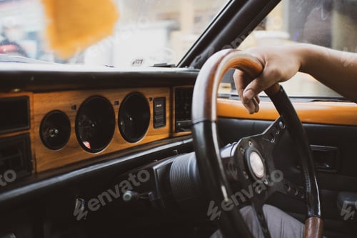 Preview: Closeup of a person driving a vintage car in the daylight