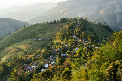 Preview: Rustic tribe village in tropical forest among lush green hill in the evening