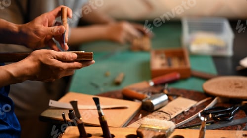 Preview: Close up shot of experienced craftsman in leather belt making process at his workshop