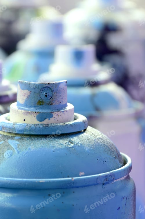 Preview: A lot of dirty and used aerosol cans of bright blue paint