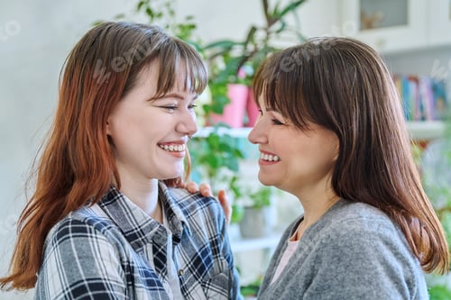 Preview: Close-up profile portrait of mother and daughter 18-20 years old.
