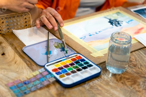 Preview: Artist Working with Watercolors at a Wooden Desk