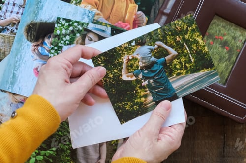 Preview: Woman looks at printed photos for family photo album.