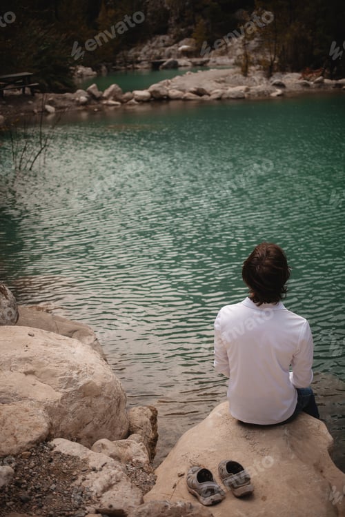Preview: Man on the background of a mountain lake, tranquility and unity with nature in Turkey. authentic