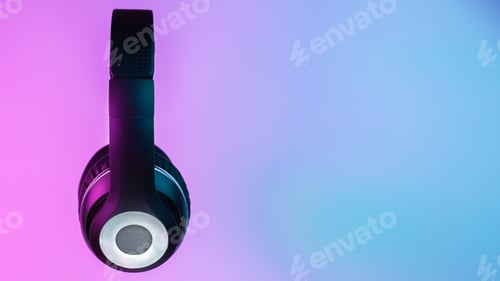 Preview: Retro 90s style photo of black stylish wireless headphone in neon lights.