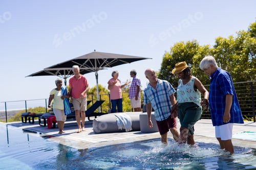 Preview: Happy senior diverse people spending time by swimming pool together in garden