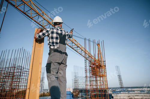 Preview: Man is working on the construction site at daytime. With wooden plank