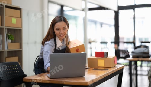 Preview: Startup small business. Asian entrepreneur using laptop computer check online order and prepare to