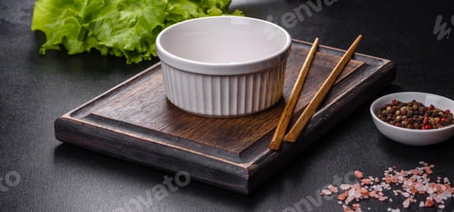 Preview: An empty white bowl and sticks on a wooden cutting board