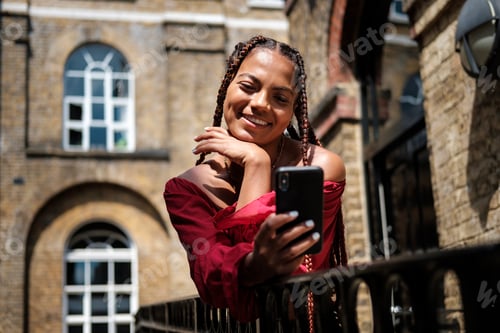 Preview: Young woman with smart phone taking selfie.
