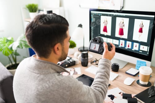 Preview: Rear view of a photographer choosing the best photos