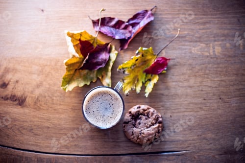Preview: Selective focus shot of a hot autumn drink with a cookie on the side on a wooden surface
