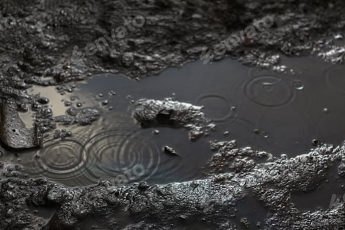 Preview: A moody and dramatic background of rainy soil ground. The defocused water rain droplet splashes in t