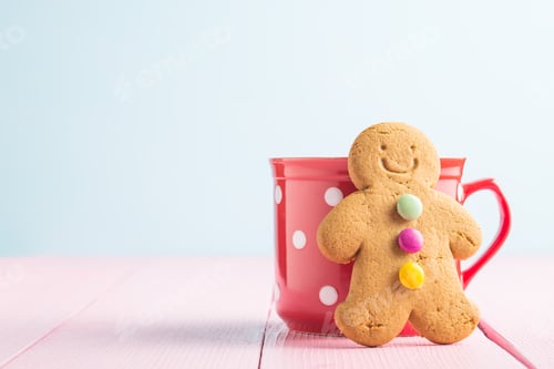 Preview: Gingerbread man leaning against a cup.