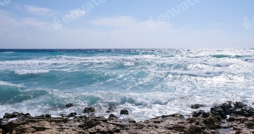 Preview: Rocky seashore with wavy ocean and waves crashing on the rocks. Stromy weather