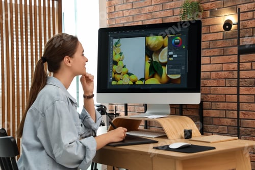 Preview: Professional retoucher working on graphic tablet at desk in office