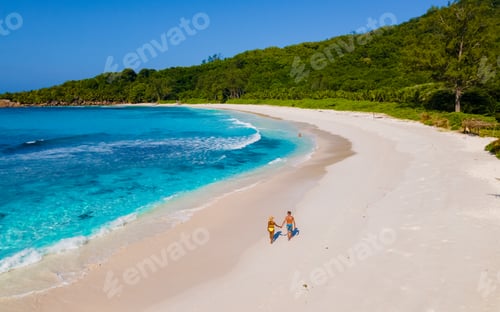 Preview: Anse Cocos La Digue Seychelles, a young couple of men and women on a tropical beach during vacation