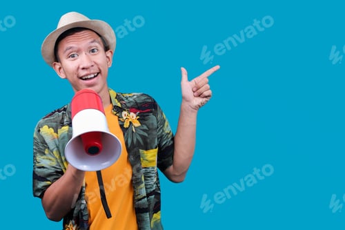 Preview: Tourist Asian Man Holding A Megaphone And Pointing To The Side Against A Blue Background