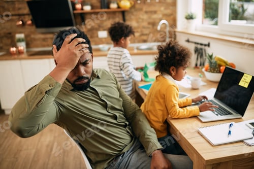 Preview: Working African American father feeling frustrated while working at home.