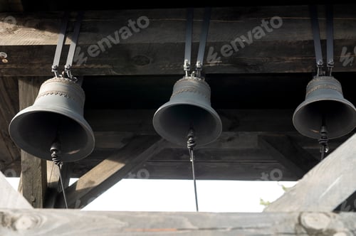 Preview: Wooden bell tower. Three black bells. Belarus, Minsk, March 2023,