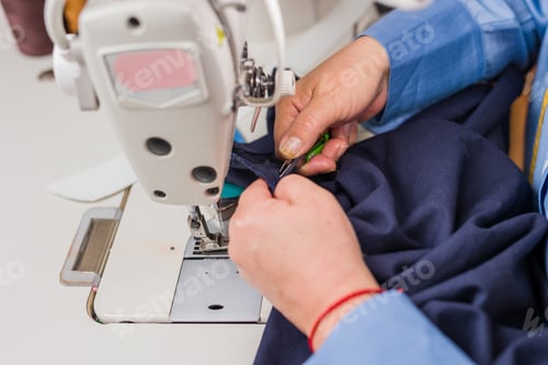 Preview: Atelier process needle detail. Unrecognizable woman hand on a sewing machine doing handmade fabric