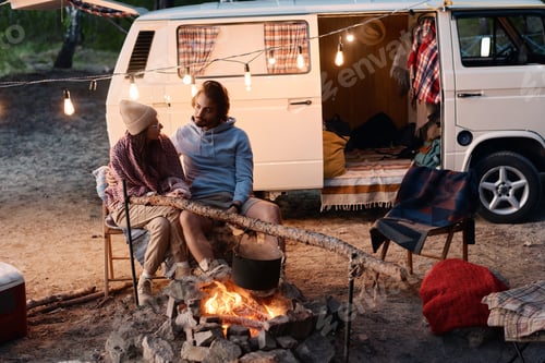 Preview: Couple sitting near the fire at camping