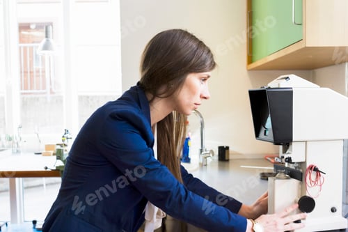 Preview: Side view of optician looking at optical equipment