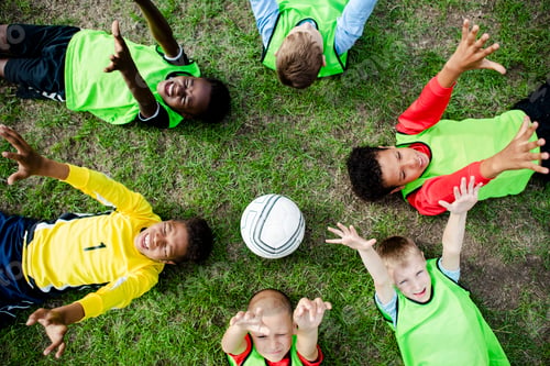 Preview: Junior football team lying around a football