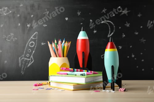 Preview: Bright toy rockets and school supplies on wooden table
