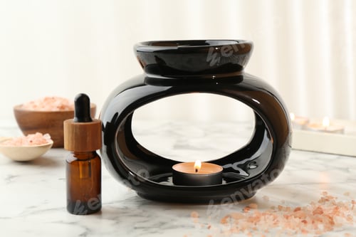 Preview: Aroma lamp with burning candle, sea salt and essential oil on white marble table, closeup