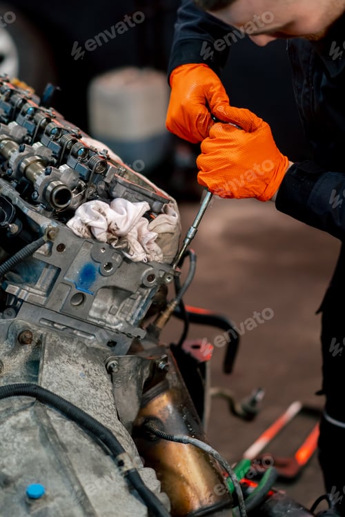 Preview: service station young master repairs a motor part removed from a car for a complete overhaul