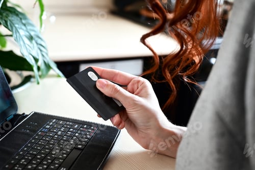 Preview: the girl makes online purchases using a credit card and a laptop