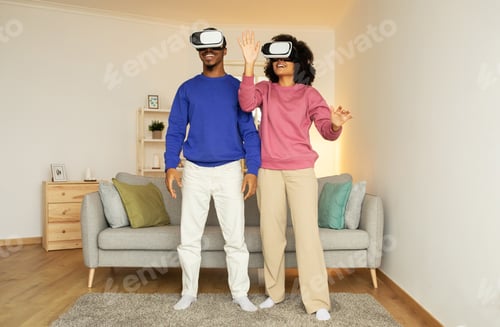 Preview: black couple fully immersed in virtual reality game at home