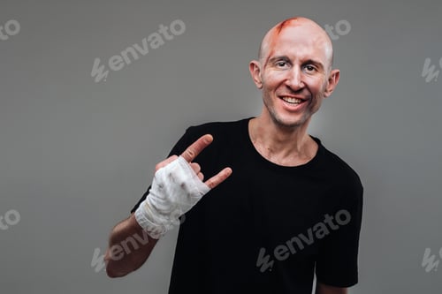 Preview: On a gray background stands a battered man in a black T-shirt With his hands wrapped up