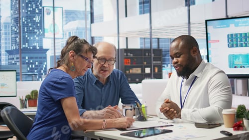 Preview: Middle aged couple explores life insurance contract terms with financial adviser
