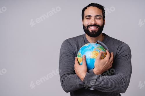 Preview: Cheerful adorable young Middle Eastern man holding globe