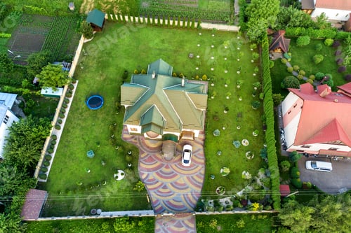 Preview: Aerial top view of house shingle roof and a car on paved yard with green grass lawn.