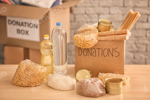 Preview: Donation box with food on table against brick wall