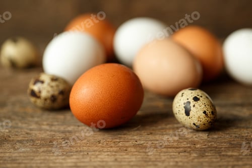 Preview: Fresh chicken and quail eggs on a wooden background
