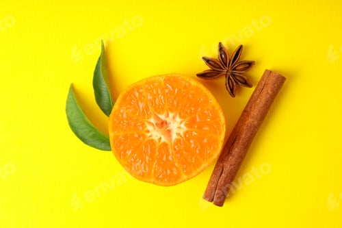 Preview: Mandarin with leaves and cinnamon on yellow background