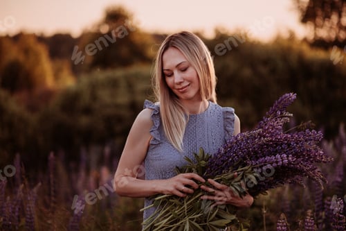 Preview: portrait beautiful girl in a blue dress in the field at sunset