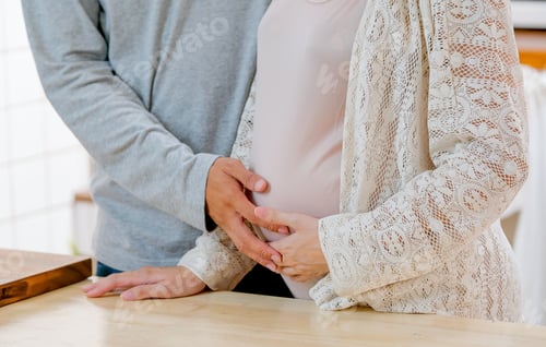 Preview: Close up of man touch the belly of pregnant woman and stand in kitchen with day light.