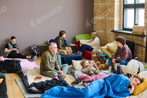 Preview: Young woman talking to mature man while both sitting on sleeping places