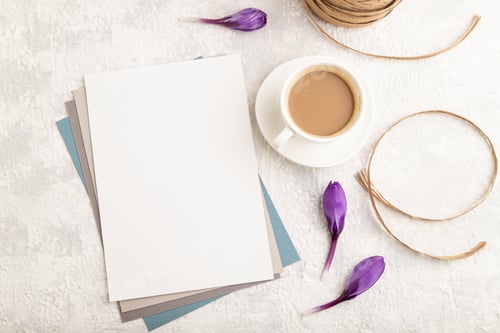 Preview: White paper sheet mockup with spring snowdrop crocus flowers and cup of coffee on gray concrete